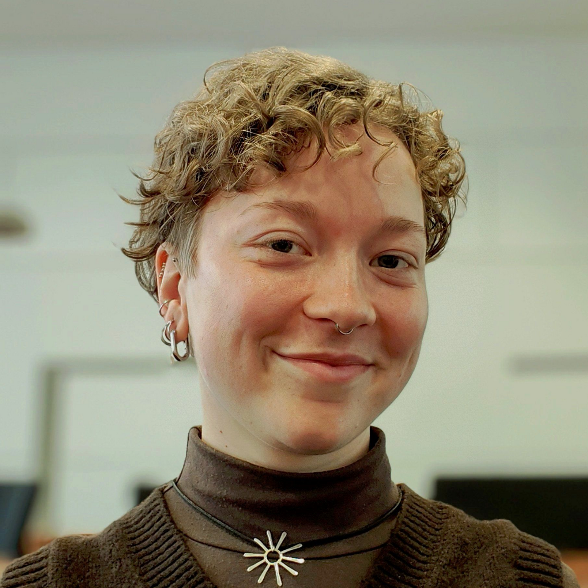 Woman with blonde hair smiling, looking at the camera.