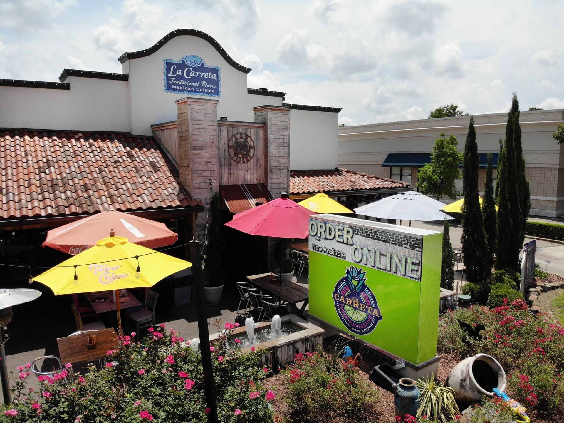 Mexican restaurant exterior with colorful umbrellas, sign