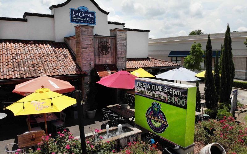 Exterior view of La Cocina restaurant with colorful umbrellas, a sign for 