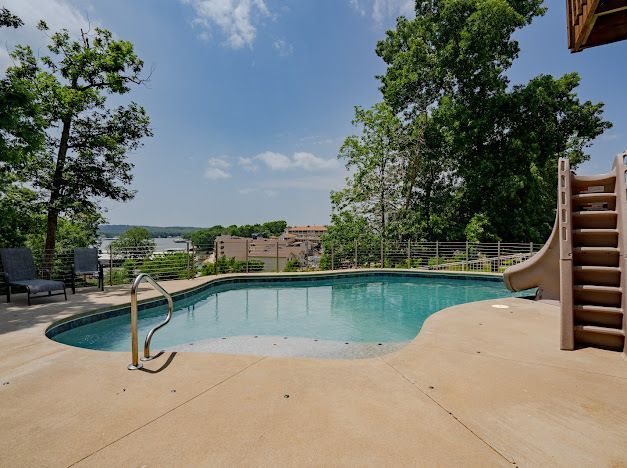 A large swimming pool with a slide in the backyard