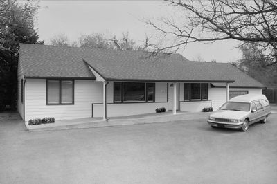 Single-story house with a car parked in the driveway.