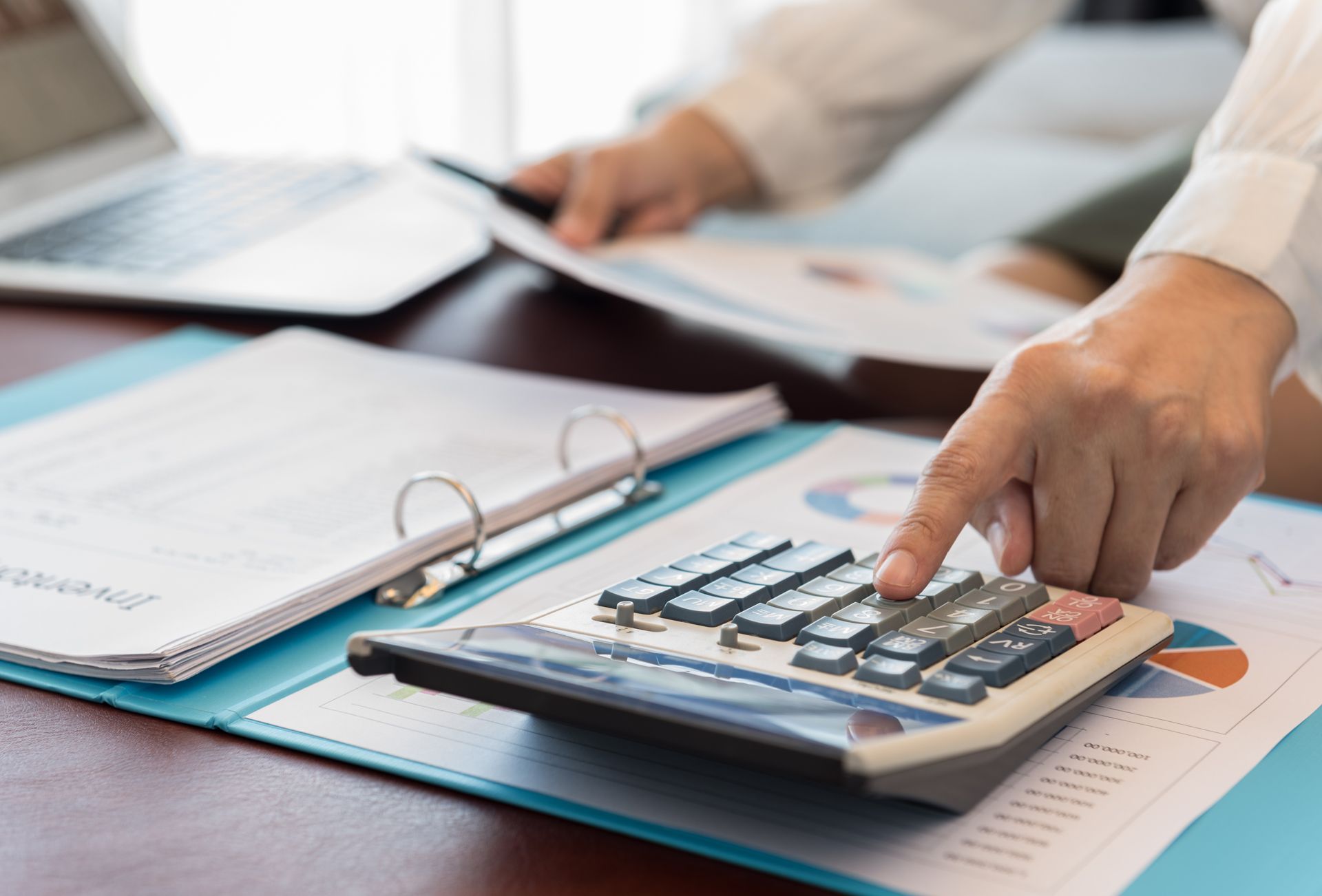 A person is using a calculator on a table