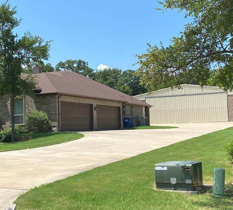 A driveway leading to a house with two garage doors
