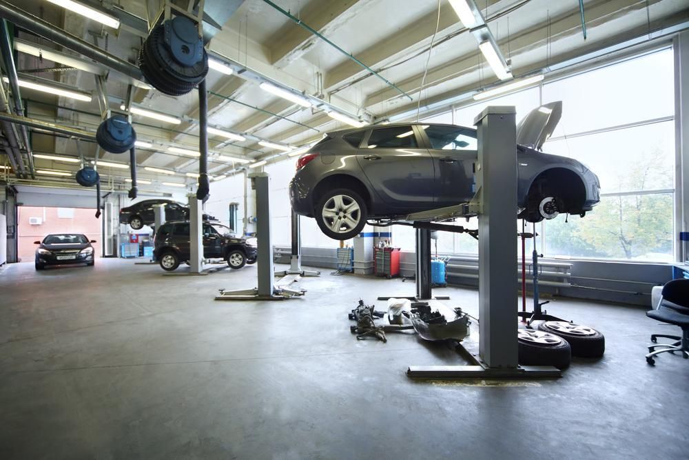 A Car is Sitting on a Lift in a Garage — Cars to Cabs In Wickham, NSW