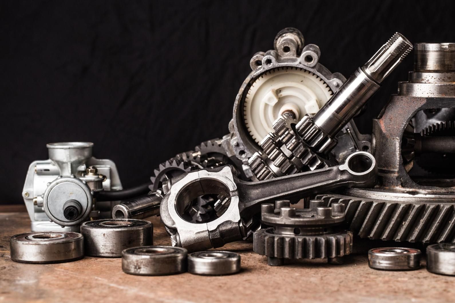 A Bunch of Metal Parts Are Sitting on a Wooden Table — Cars to Cabs In Wickham, NSW
