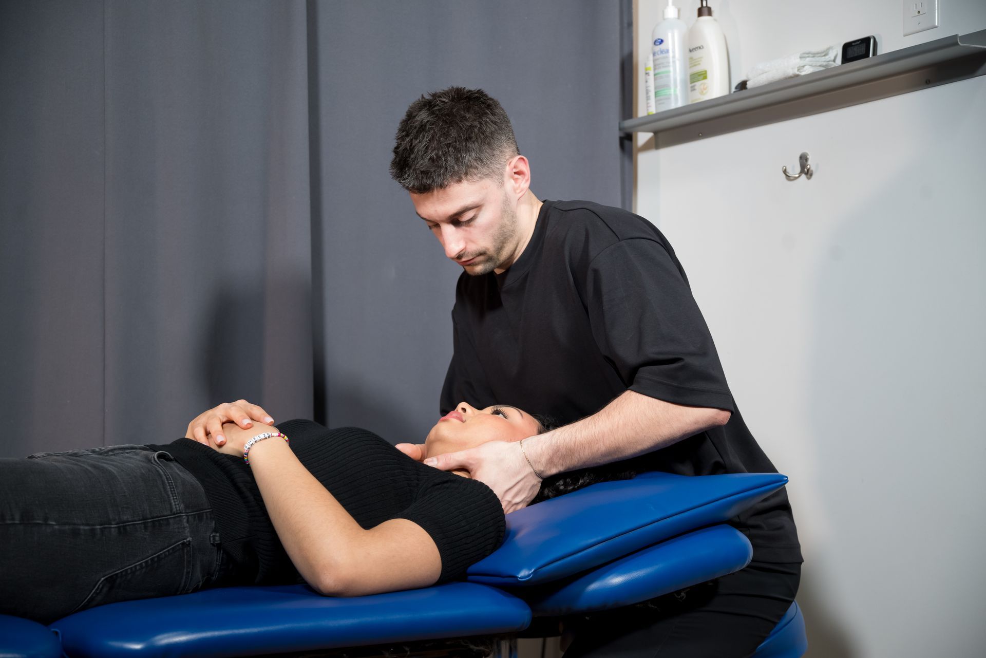 physiotherapy for concussion, man mobilzing the neck joints of a woman 