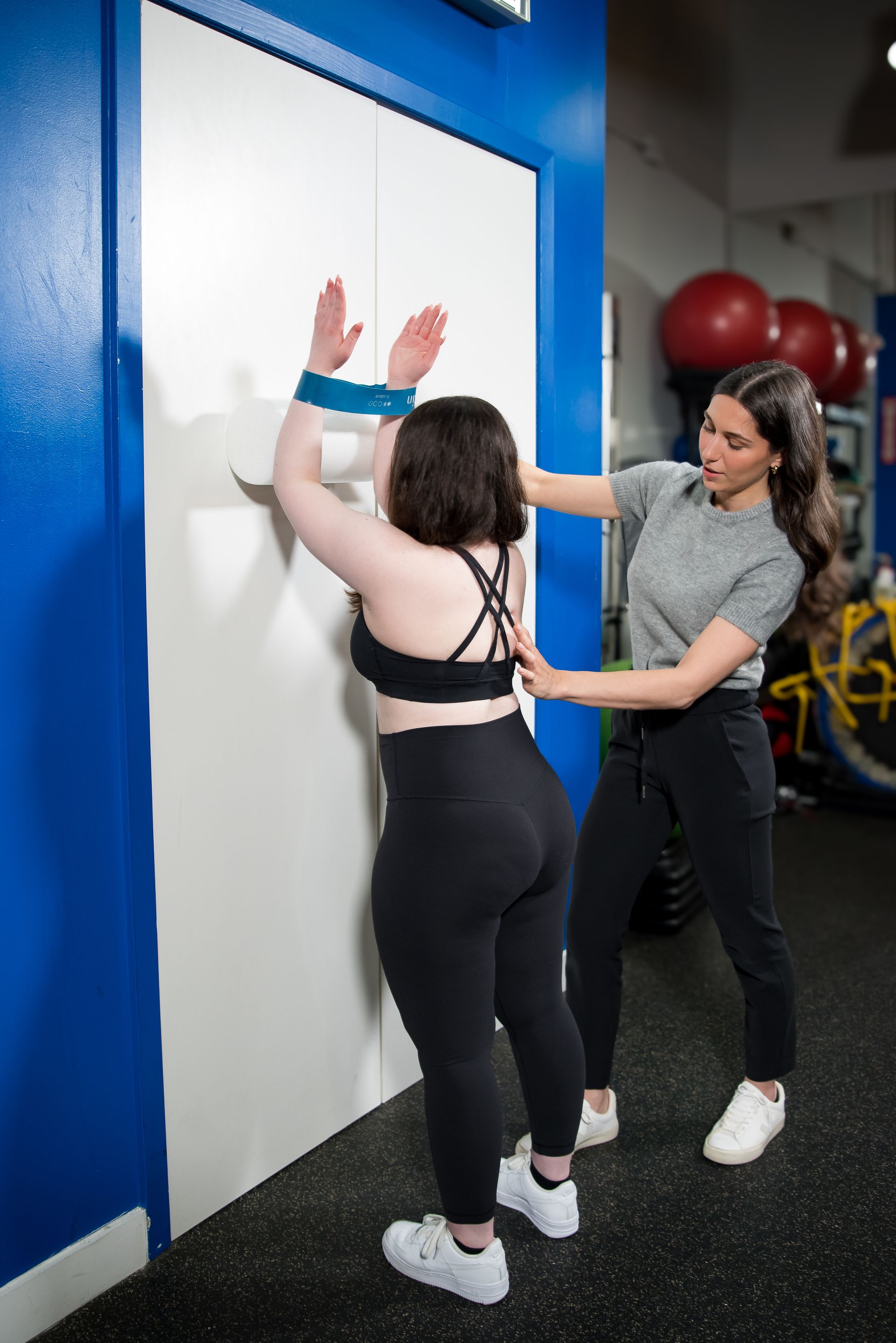 Physio Dominique Tersigni assisting a female client with shoulder exercises