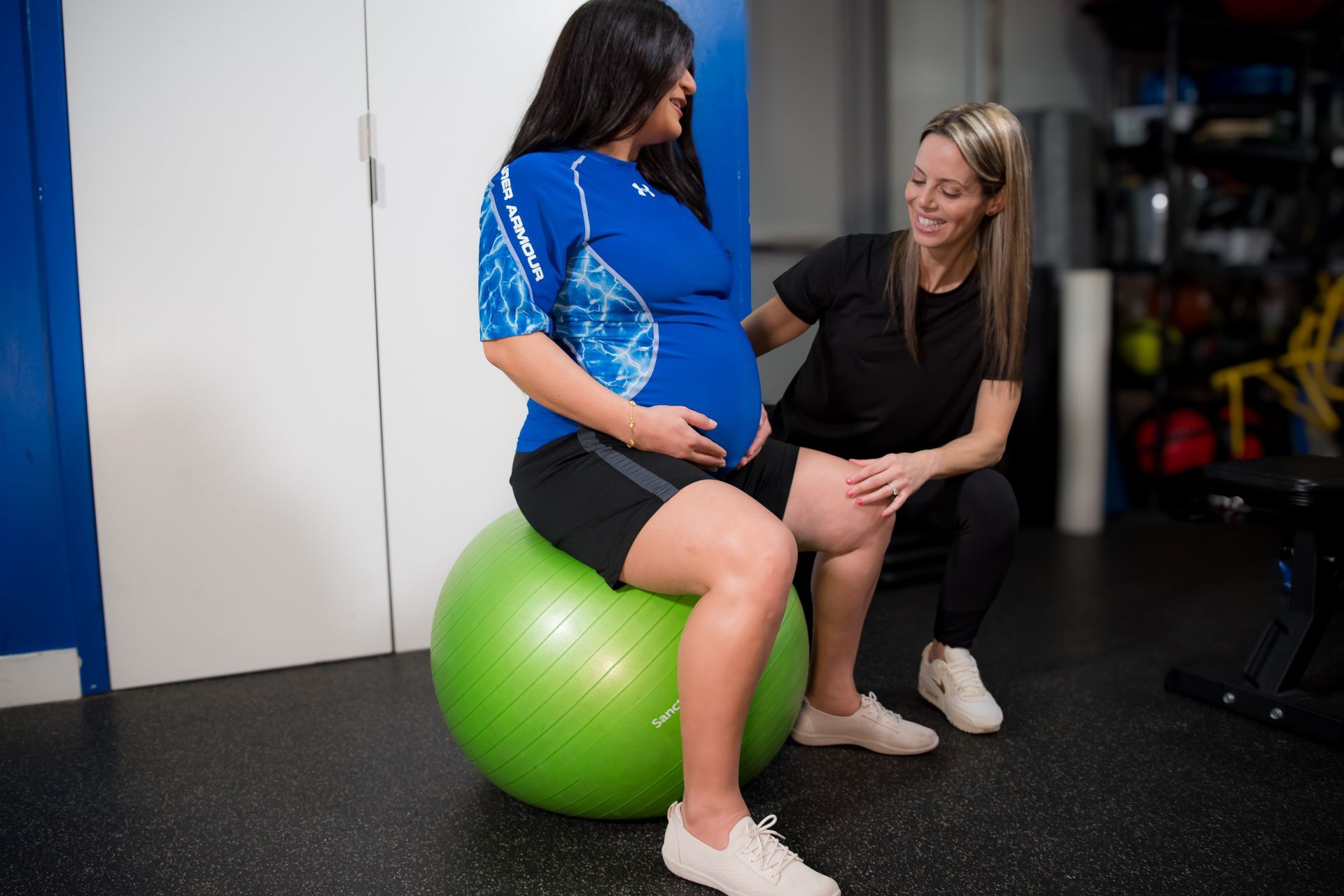 a pregnant woman working out with an exercise ball