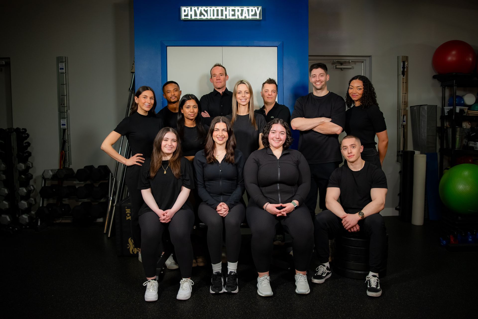 Sporting Edge team are posing for a picture in front of a sign that says physiotherapy.
