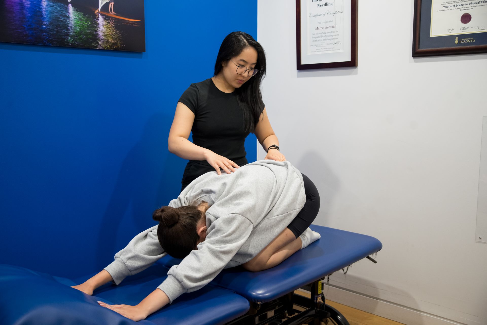 woman receiving physiotherapy treatment on a plinth in childs pose