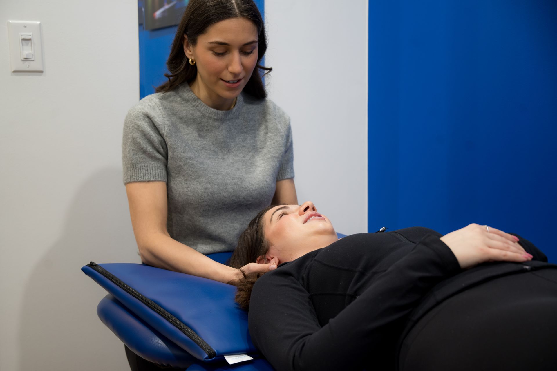 Woman receiving neck treatment from therapist after sustaining a concussion