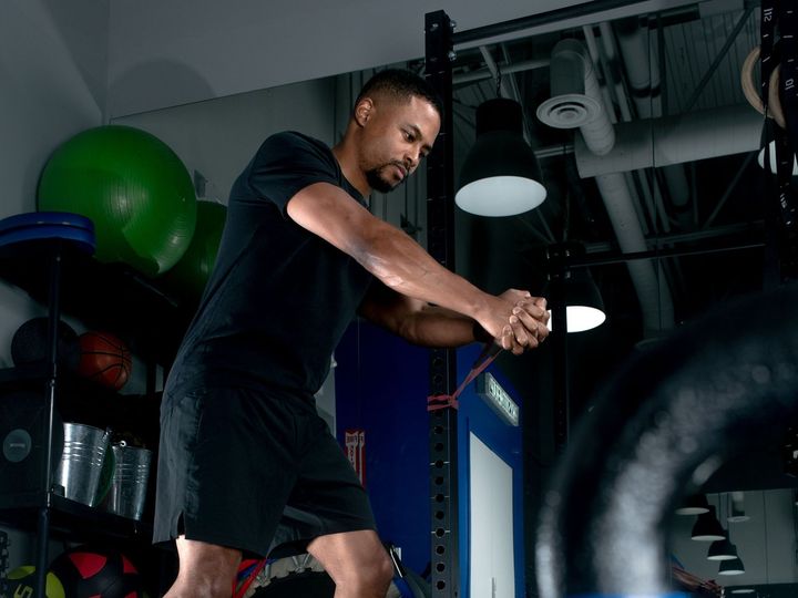 a man is using a resistance band in a gym to strengthen rotation patterns used in sport