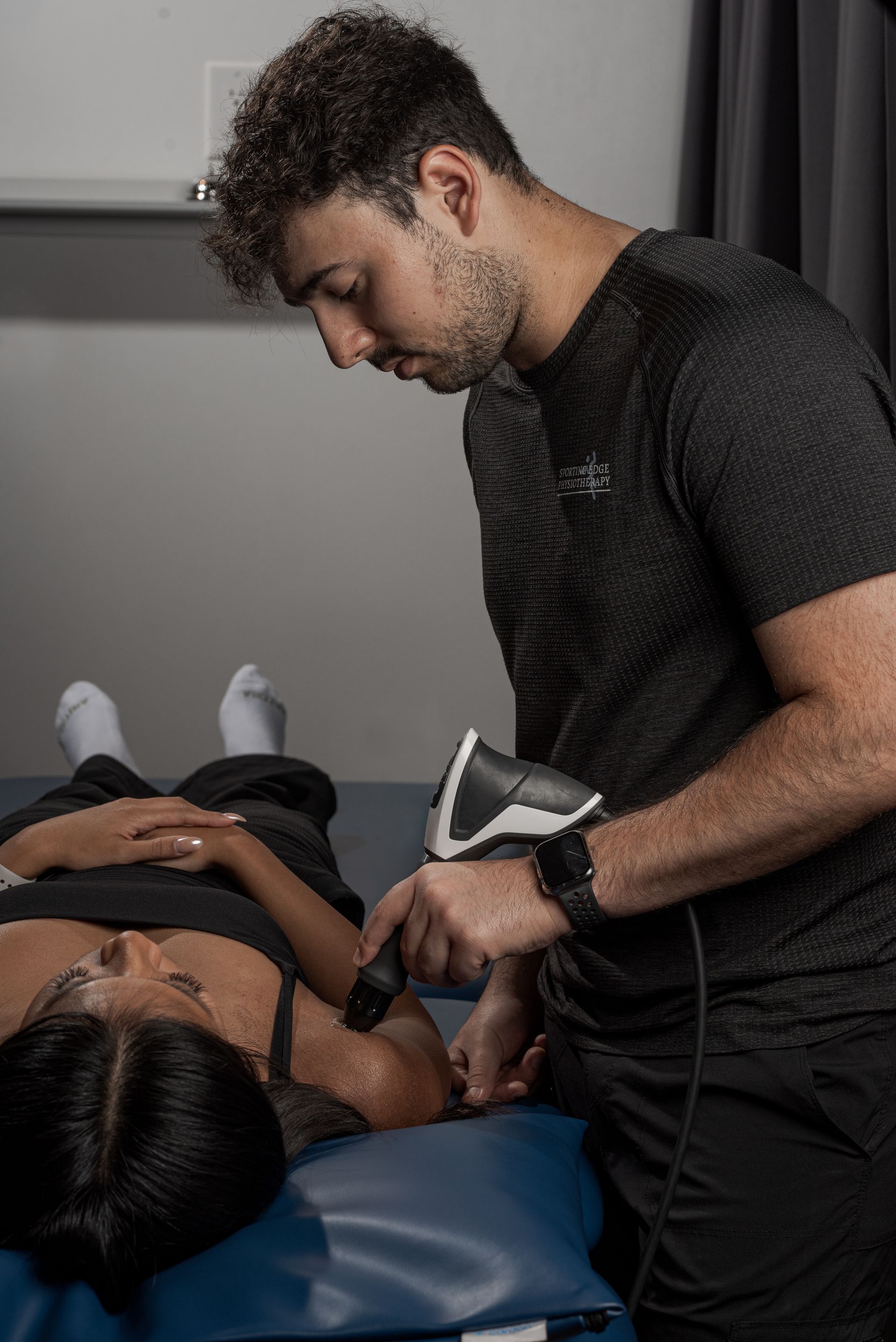 shockwave therapy on the shoulder of a female client