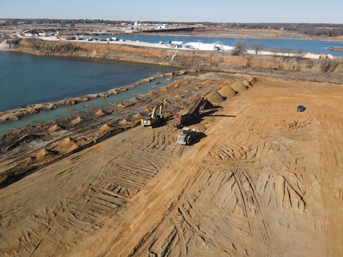 An aerial view of a construction site next to a body of water