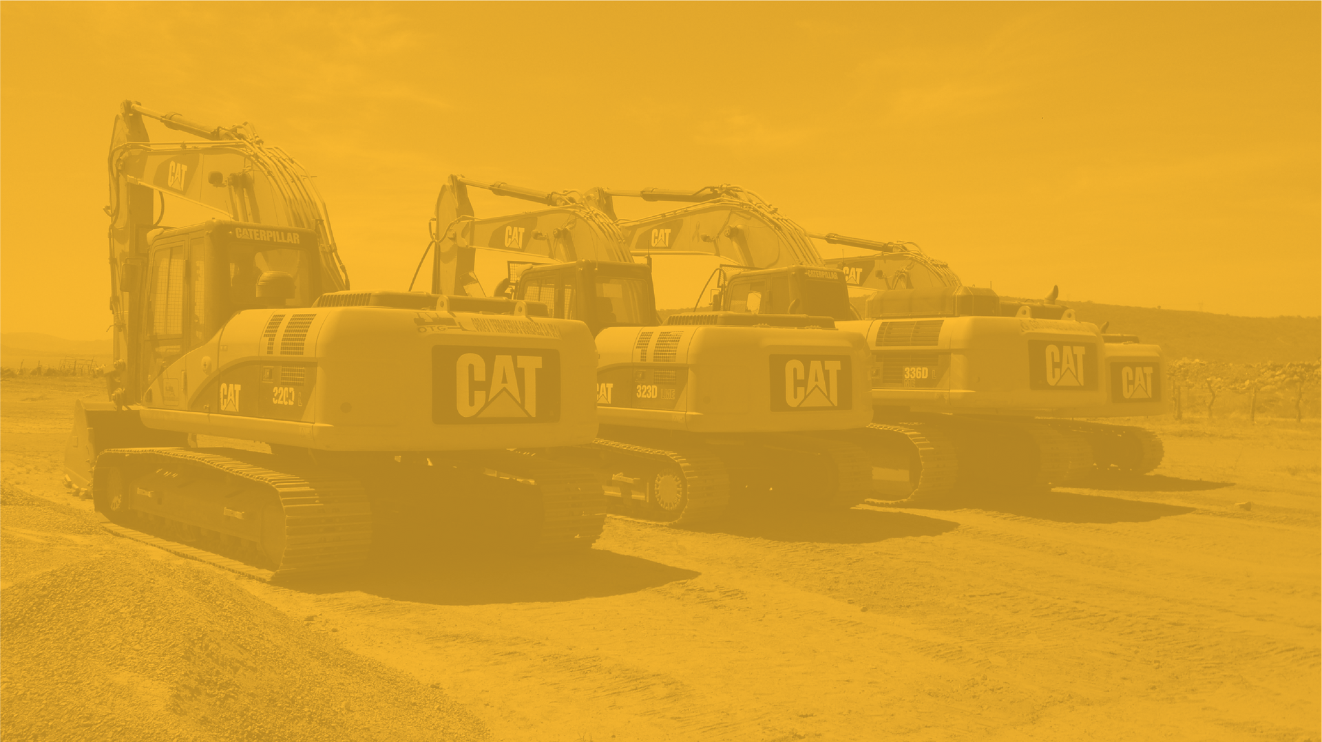 Vista con tonalidad amarillenta de varias excavadoras Caterpillar en fila, al aire libre.