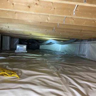 Crawl space with white vapor barrier on the floor and walls. A/C unit is visible in the corner.