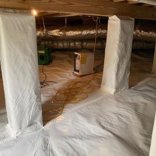 Crawl space with white vapor barrier on the floor and walls. A/C unit is visible in the corner.