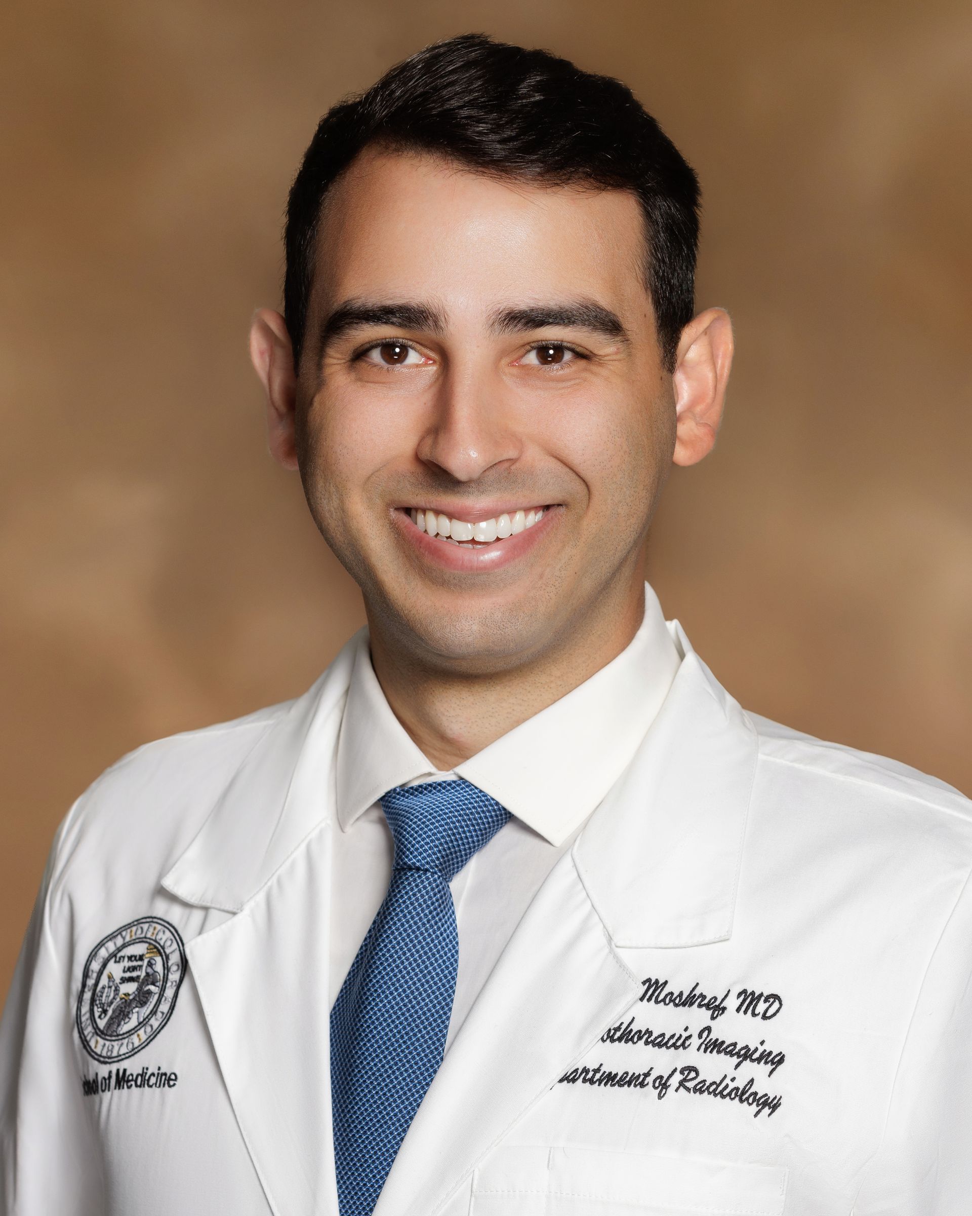 A man wearing a white lab coat and a blue tie