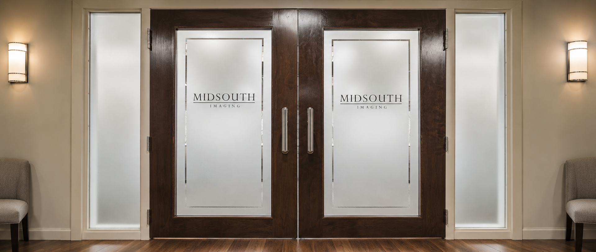 Pair of frosted glass double doors with dark wood frame in a beige hallway, lit by wall sconces.