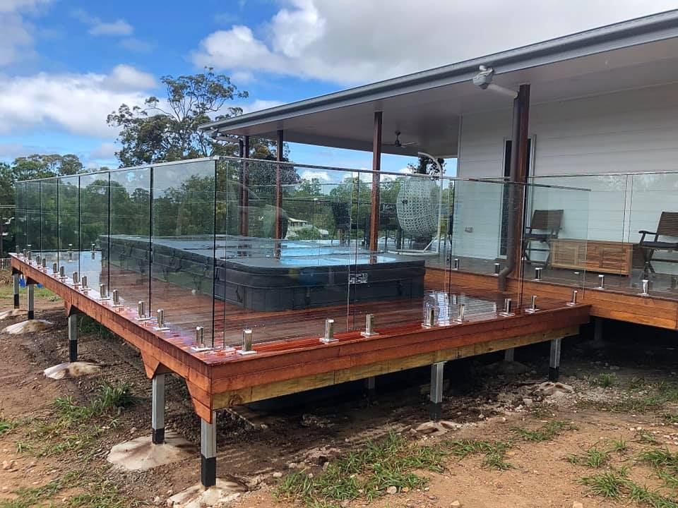A Large Swimming Pool With Glass Fencing — RBG Building & Maintenance in Veteran, QLD