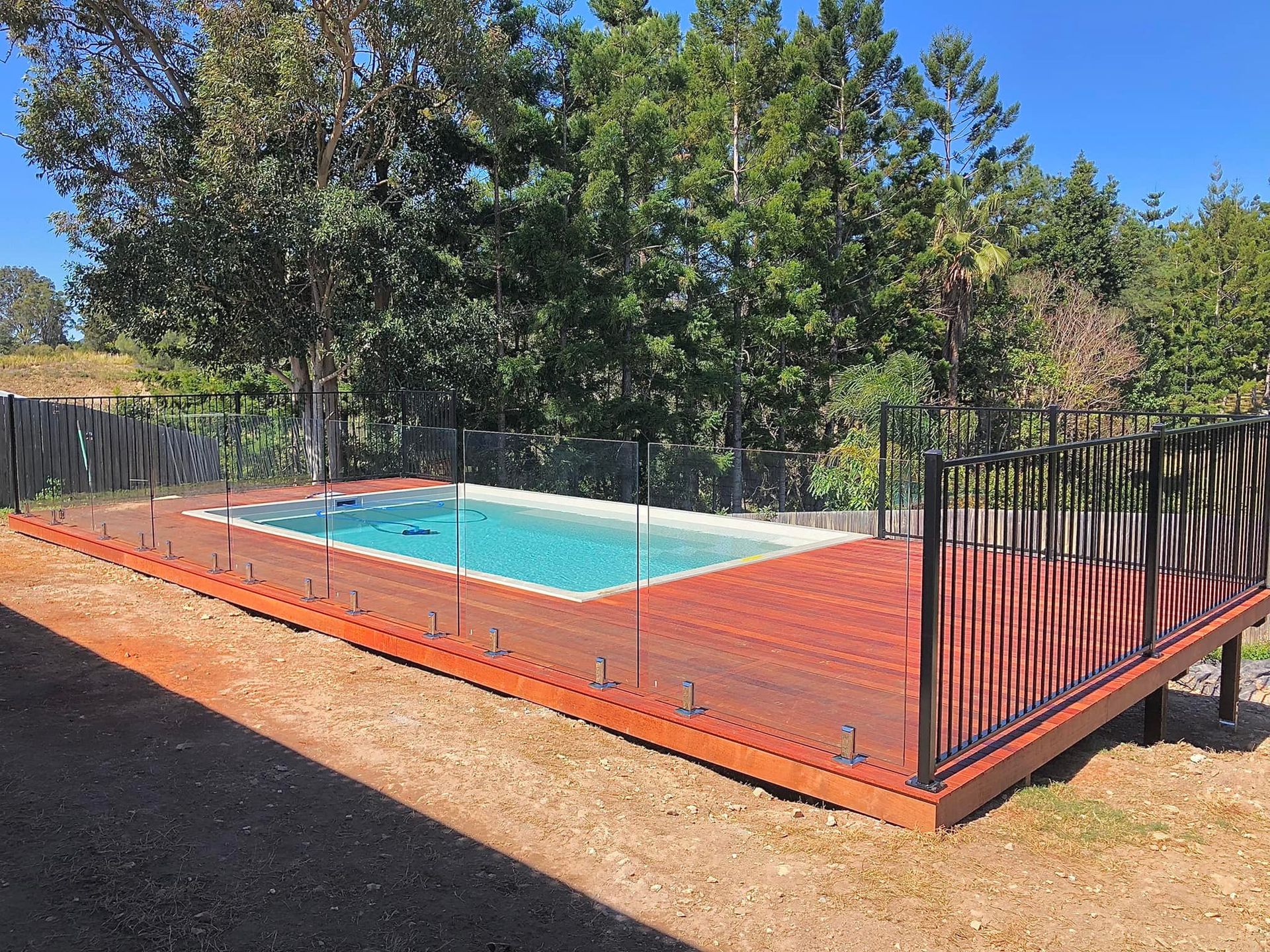 A Swimming Pool Surrounded by Trees and Fence — RBG Building & Maintenance in Chatsworth, QLD