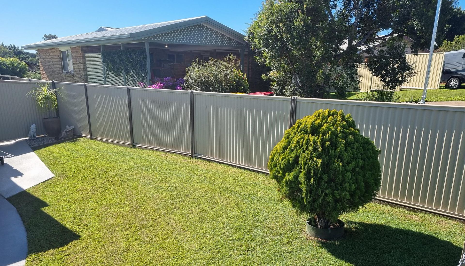 A Wooden Fence Surrounds a Grassy Field With a Tree in the Background — RBG Building & Maintenance in Kilkivan, QLD