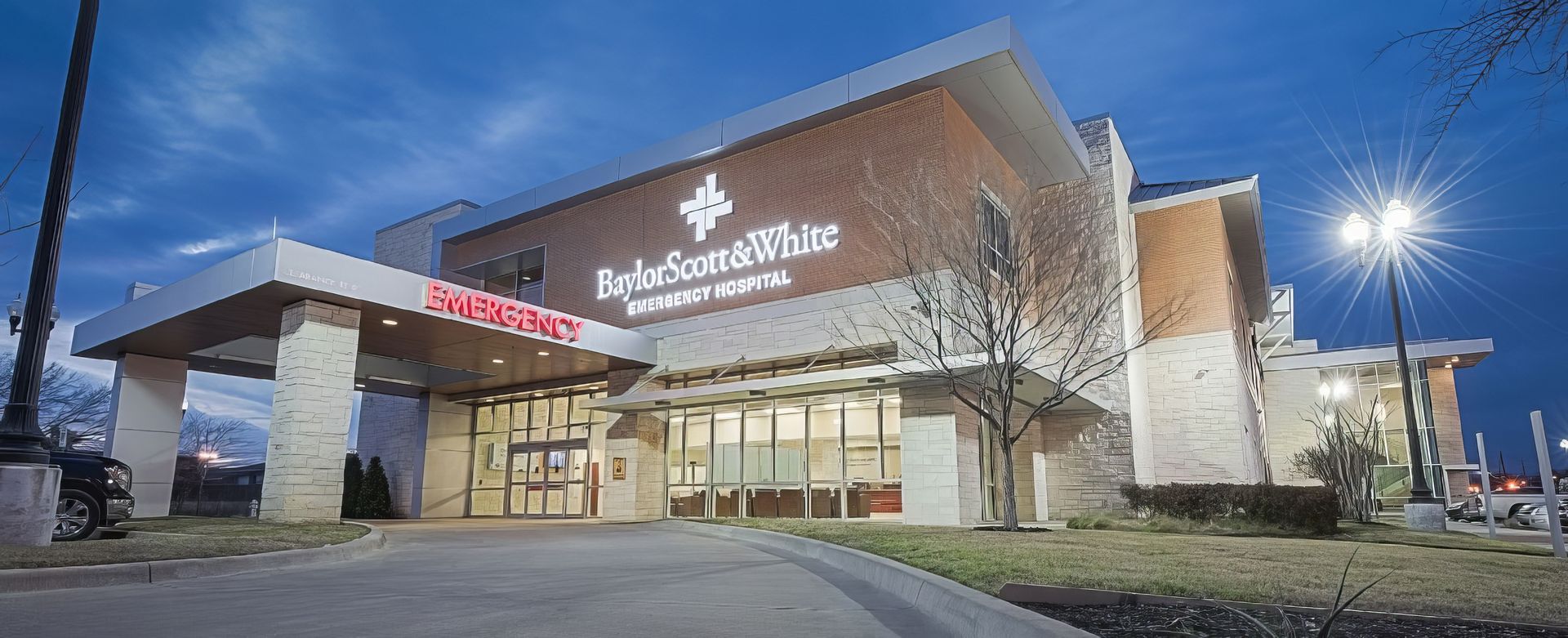 Walgreens pharmacy storefront at dusk with illuminated entrance and parking lot lights