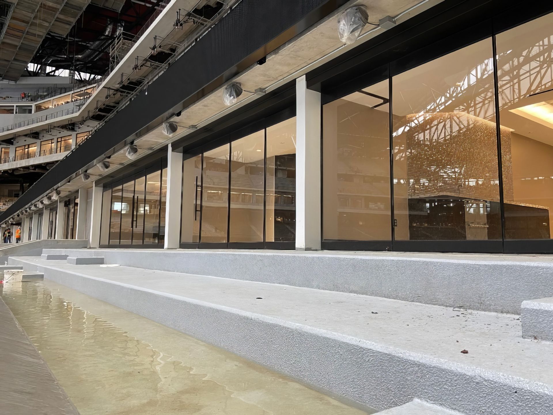 Modern building with glass windows and concrete steps beside shallow water