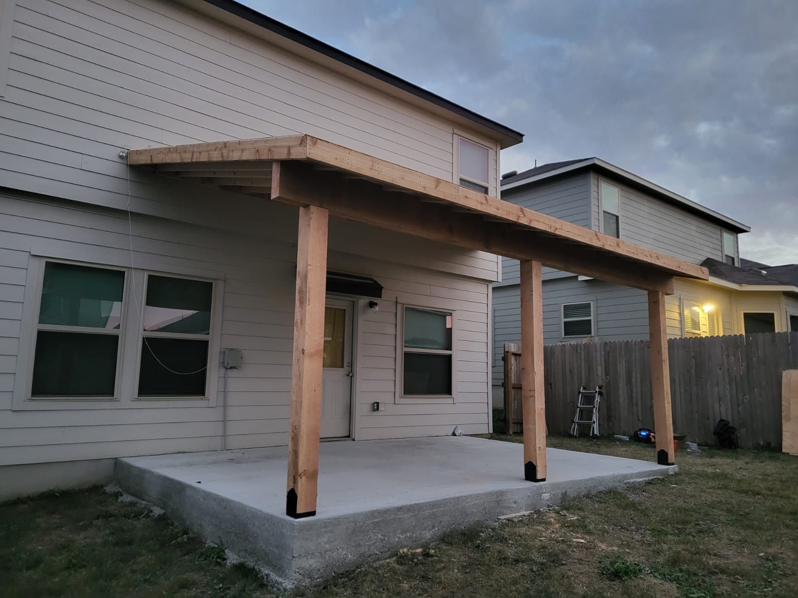 A house with a wooden covered patio in the backyard.