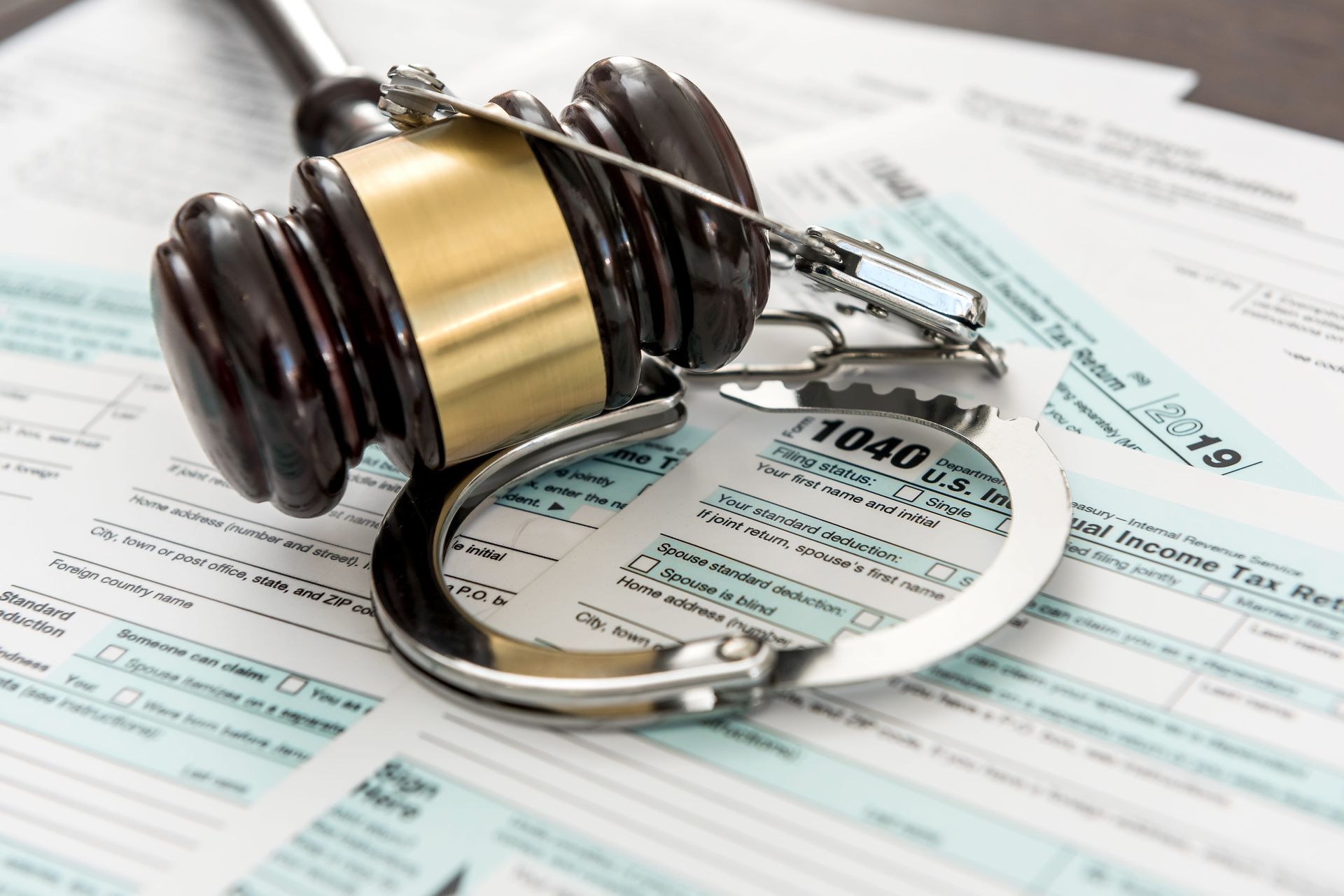 Judge’s gavel and handcuffs resting on legal documents with a court form underneath
