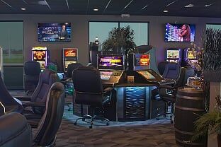 A casino with a lot of chairs and a lot of slots.