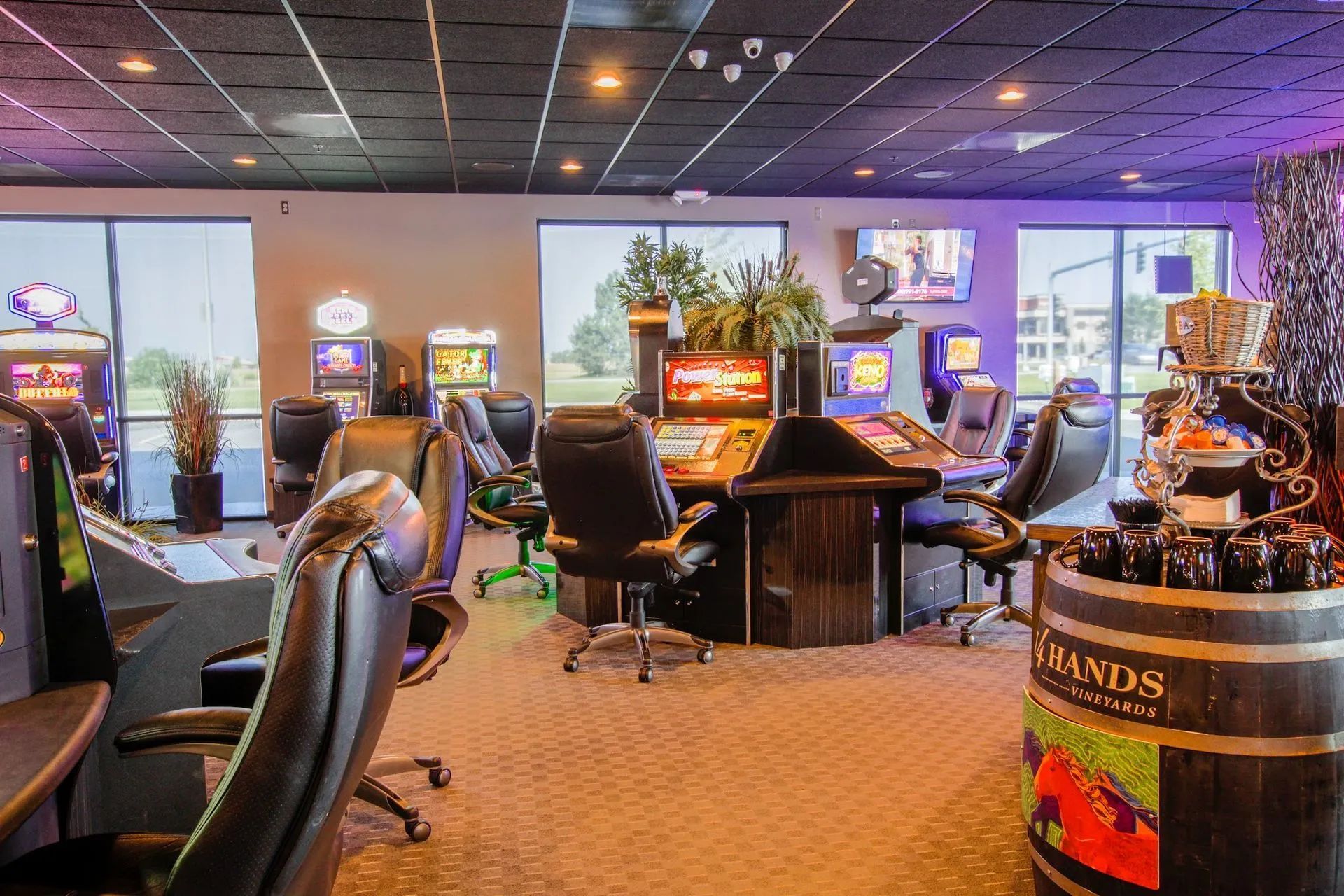 Casino gaming room with rows of slot machines and chairs under warm lighting