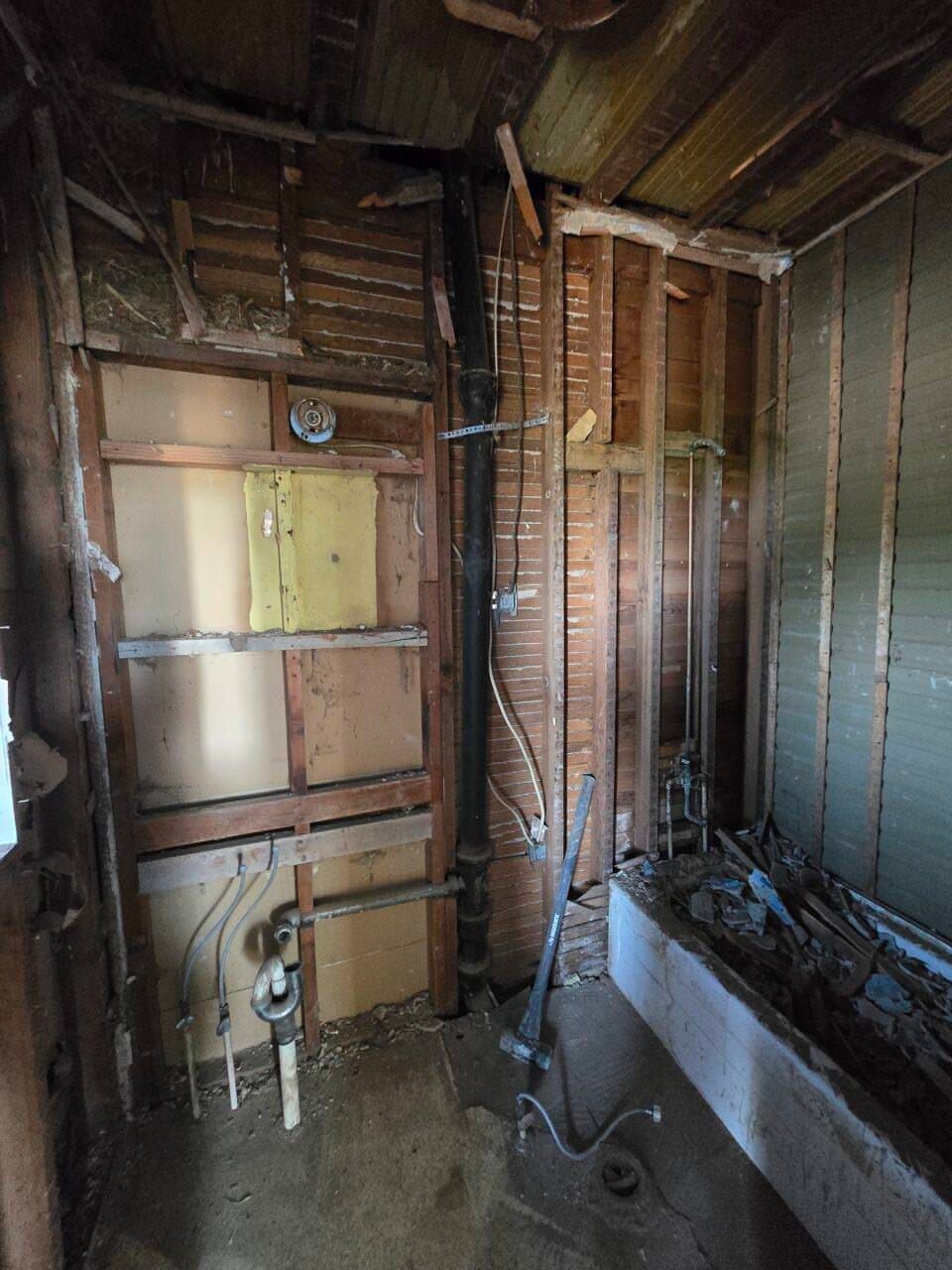 Unfinished bathroom with exposed studs, plumbing, and a partially installed bathtub. Unfinished bathroom with exposed studs, plumbing, and a partially installed bathtub.