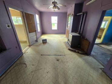 Narrow hallway with white walls, brown door, ceiling tiles, and a small window at the end. Narrow hallway with white walls, brown door, ceiling tiles, and a small window at the end.