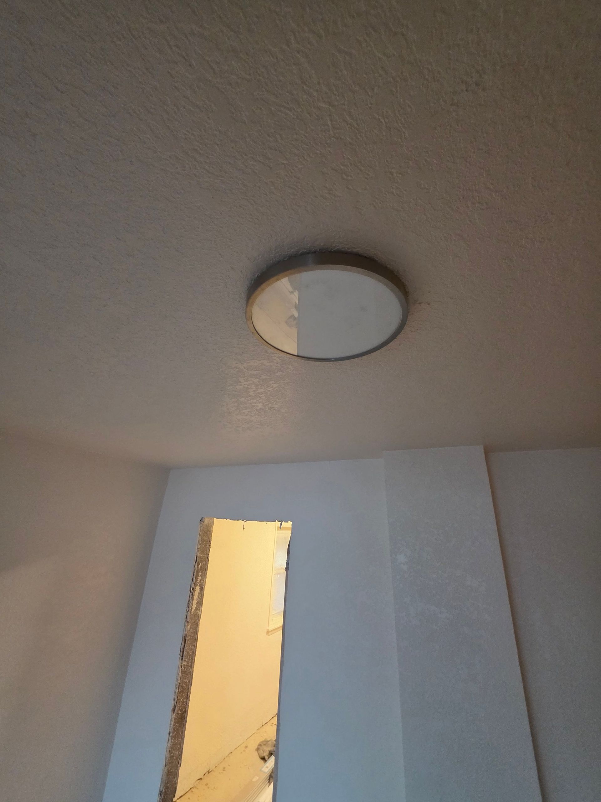 Ceiling light above a narrow doorway in a dim hallway Ceiling light above a narrow doorway in a dim hallway