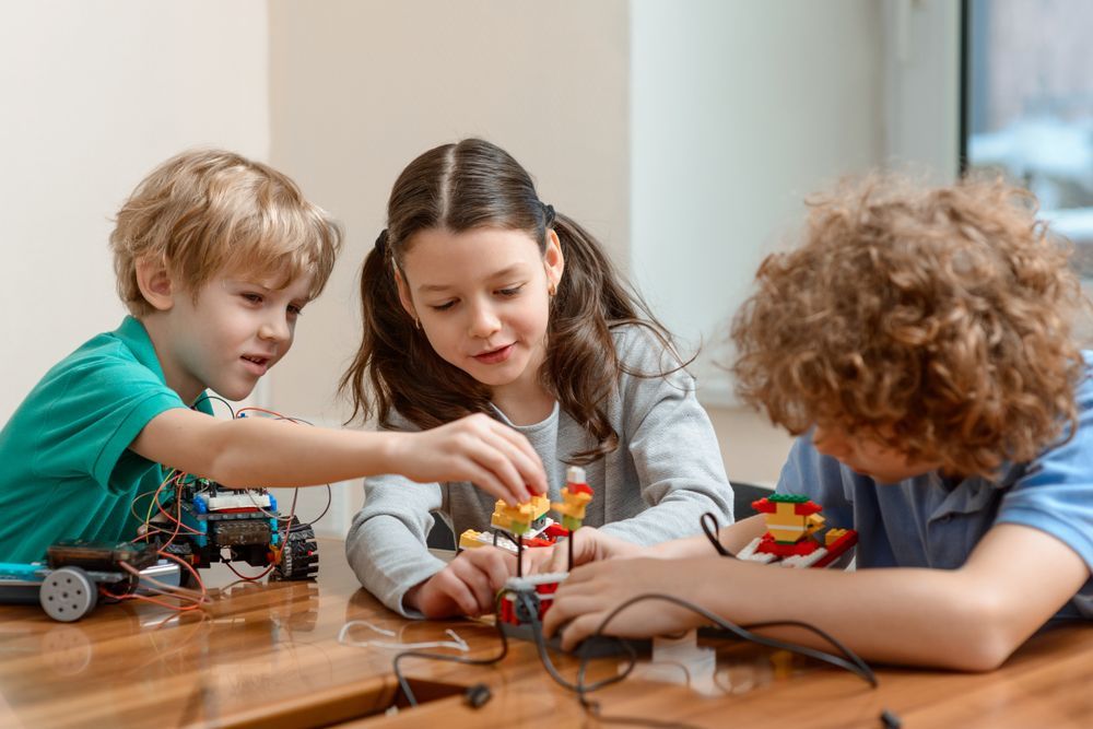 Three Children Are Playing With Lego Robots At A Table — The Therapists Cairns In Cairns City, QLD