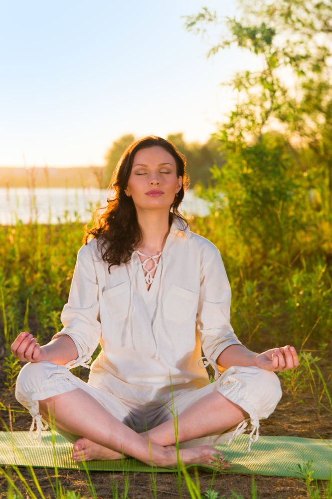 A Woman Is Sitting In A Lotus Position On A Yoga Mat — The Therapists Cairns In Cairns City, QLD