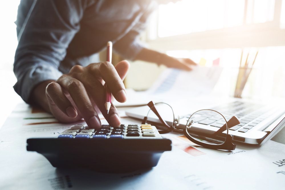 Accountant Calculating Business Data With A Pen And A Calculator — Dynamic Accounting Taxation Advisors in Bateau Bay, NSW