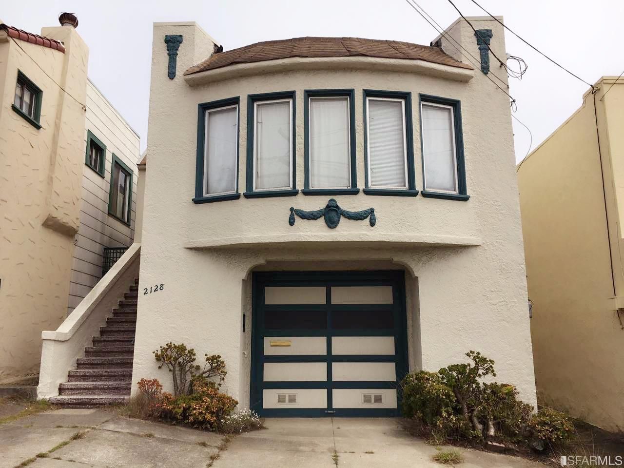 A white house with a blue garage door and stairs