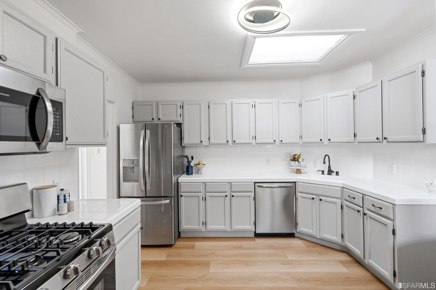 A kitchen with white cabinets and stainless steel appliances