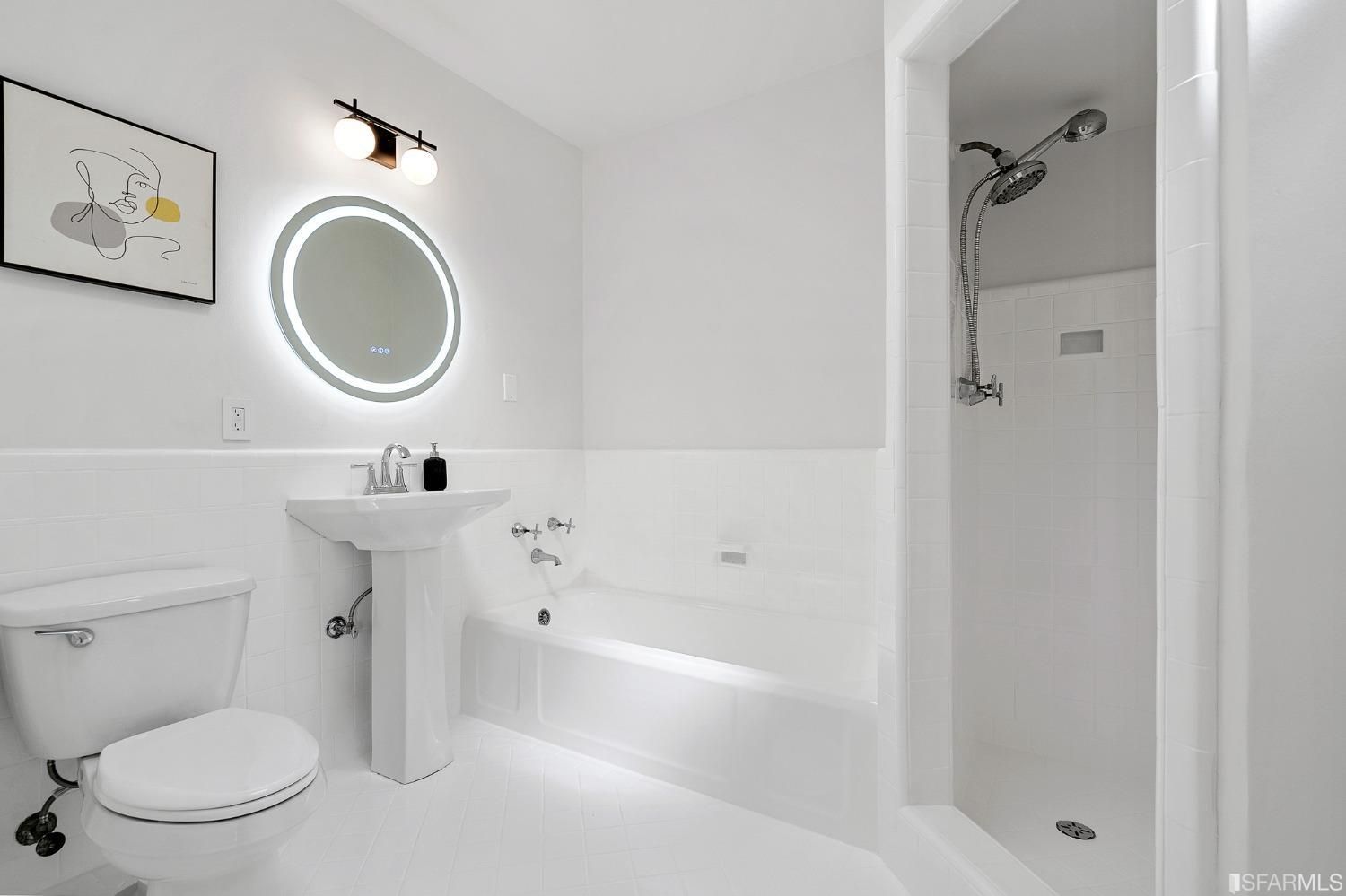 A bathroom with a toilet , sink , bathtub and shower.