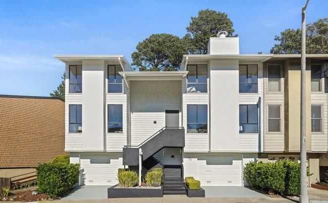 A large white apartment building with stairs leading up to it