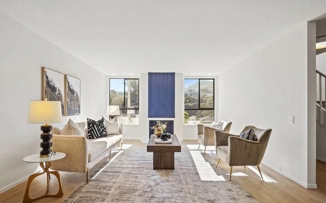 A living room with a couch , chairs , and a coffee table.