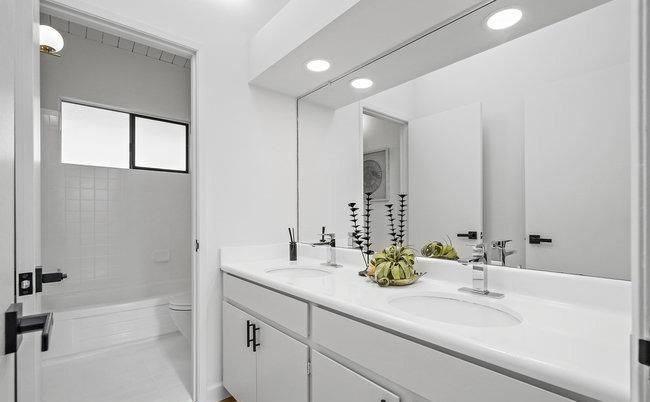 A bathroom with two sinks and a large mirror.