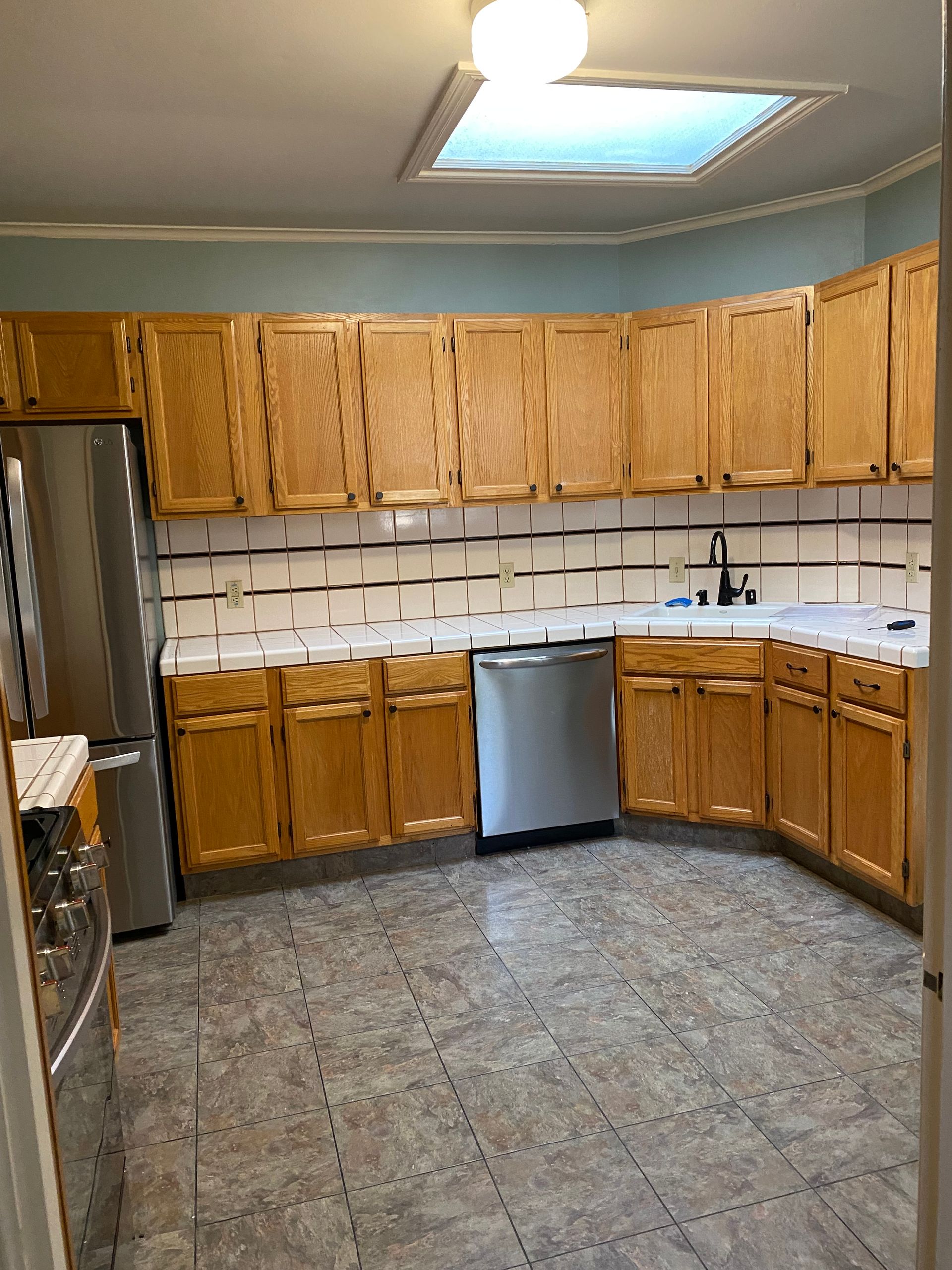A kitchen with wooden cabinets and stainless steel appliances