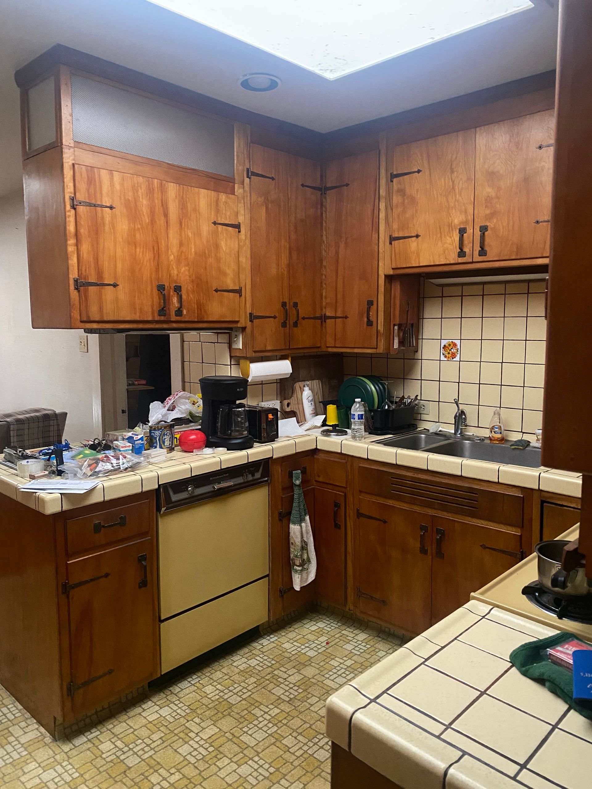 A kitchen with wooden cabinets , a dishwasher , a sink , and a stove.