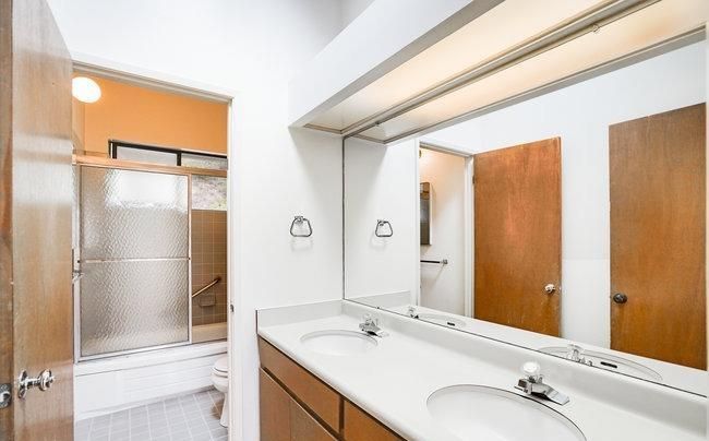 A bathroom with two sinks and a large mirror.