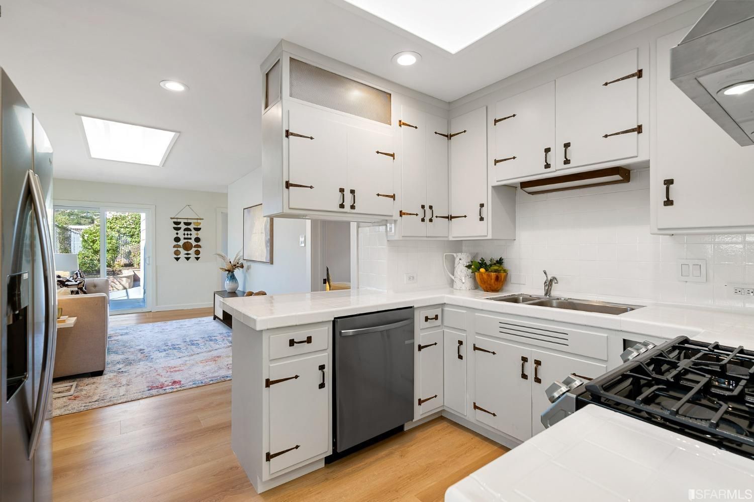 A kitchen with white cabinets and stainless steel appliances