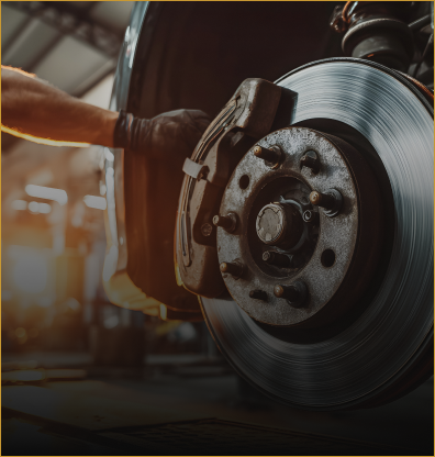 Mechanic using an angle grinder on a car brake disc in a dim auto shop | The Family Mechanics - Cherry Hill