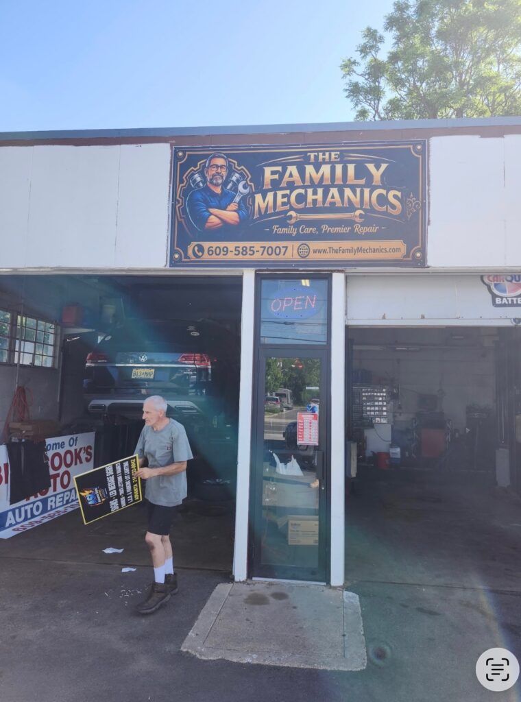 The Family Mechanics storefront with open garage bays and a person standing near the entrance| The Family Mechanics - Cherry Hill